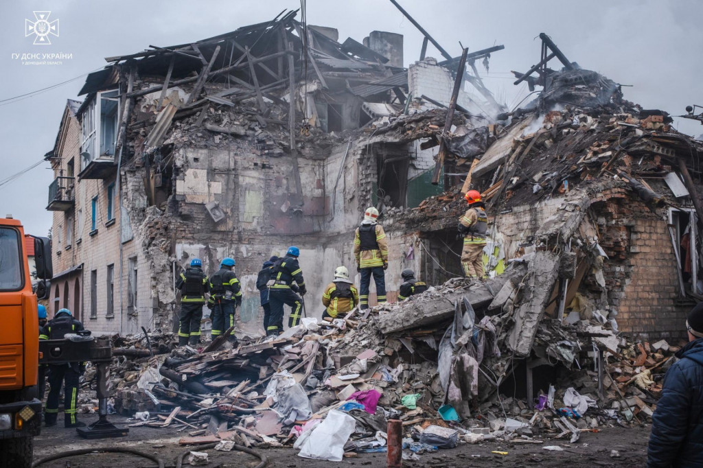 Záchranné práce na mieste obytného domu ťažko poškodeného ruským raketovým útokom. FOTO: Reuters