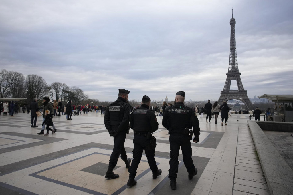 Policajti hliadkujú neďaleko Eiffelovej veže v Paríži. FOTO: TASR/AP