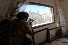 Izraelský vojak strieľa zo zbrane z okna počas operácií v pásme Gazy. FOTO: REUTERS/IDF