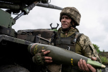Ukrajinský vojak nesie náboj zo samohybnej húfnice Caesar pred streľbou na ruské jednotky. FOTO: Reuters