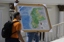 Muž nesie novú mapu Venezuely s regiónom Essequibo, rozsiahlym územím, ktoré spravuje a kontroluje Guyana, na ktoré si nárokuje Venezuela do budovy parlamentu v Caracase. FOTO TASR/AP