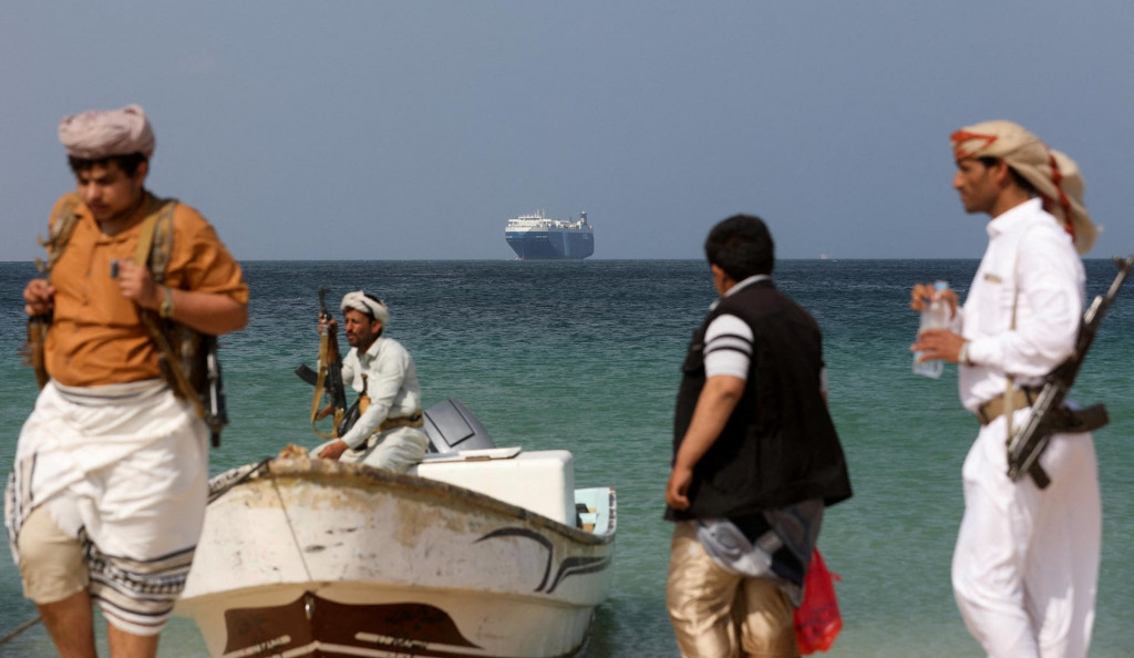 Ozbrojení muži stoja na pláži, keď komerčná loď Galaxy Leader, ktorú minulý mesiac zadržali jemenskí Húsíovia, kotvila pri pobreží al-Salif. FOTO: Reuters