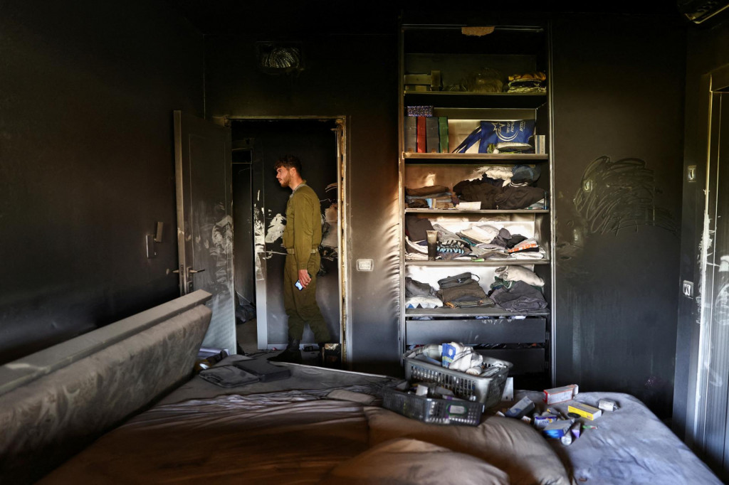 Izraelský vojak kontroluje vyhorený dom v kibuci Beeri, ktorý bol dva mesiace opustený po smrtiacom útoku ozbrojencov z palestínskej militantnej skupiny Hamas. FOTO: Reuters