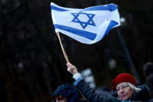 Účastníčka demonštrácie v blízkosti Brandenburskej brány drží izraelskú vlajku a protestuje proti antisemitizmu. FOTO: Reuters