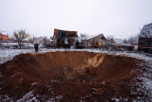Miestny obyvateľ stojí vedľa krátera na mieste ruského raketového útoku v Kyjeve. FOTO: Reuters