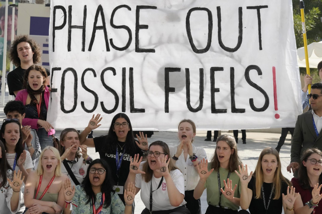 Aktivisti protestujú s transparentom proti fosílnym palivám na Klimatickej konferencii OSN COP 28 v Dubaji. FOTO: TASR/AP