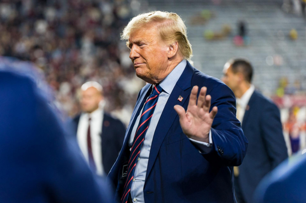 Donald Trump máva na rozlúčku pri odchode z ihriska počas zápasu v americkom futbale. FOTO: Reuters