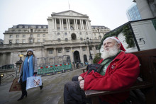 Gerard White, ktorý má na hlave santovskú čiapku, čaká na svoju manželku pred budovou britskej centrálnej banky v Londýne. FOTO: TASR/AP