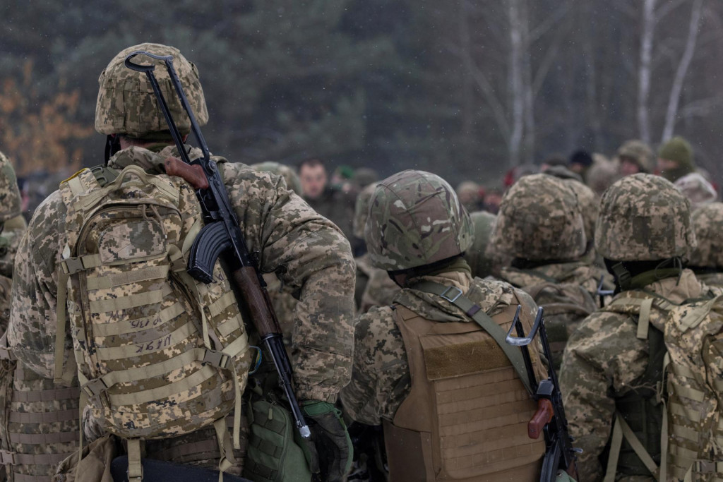Ukrajinskí vojaci stoja s puškami po vojenskom výcviku v poľskom Wedrzyne. FOTO: REUTERS