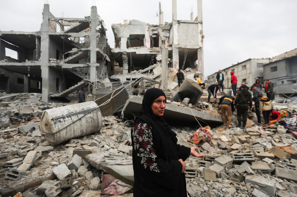 Ľudia kontrolujú miesto izraelských útokov na domy v Chán Júnis v južnom pásme Gazy. FOTO: Reuters