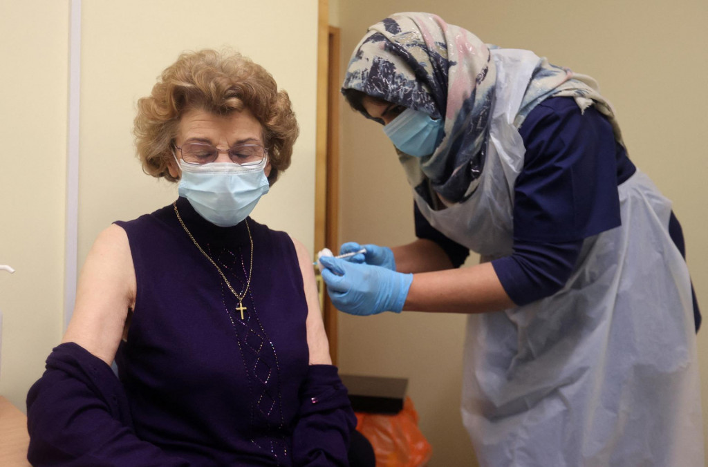 Pacient dostáva prvú z dvoch injekcií s dávkou vakcíny Pfizer-BioNtech covid-19. FOTO: Reuters