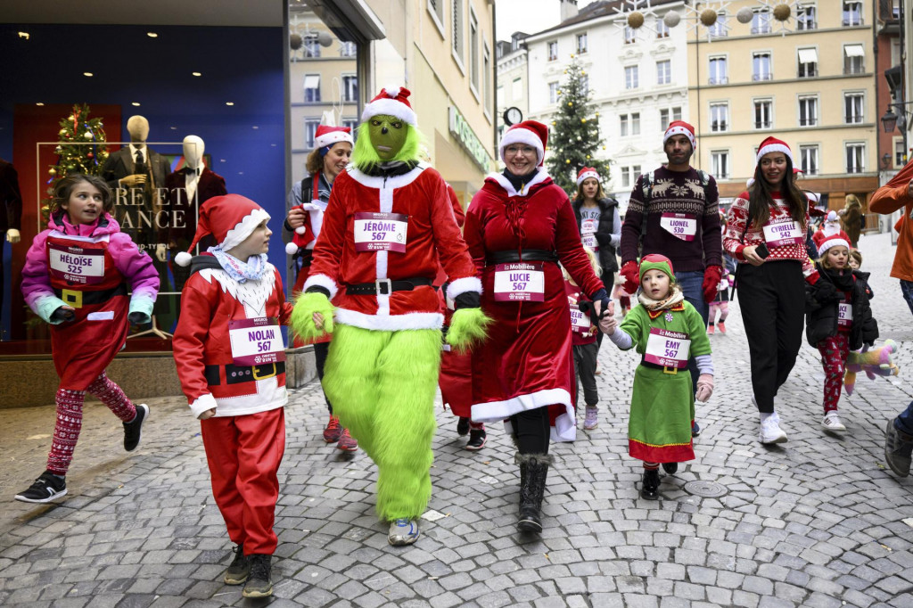 Bežci oblečení vo vianočných kostýmoch sa zúčastňujú na 16. ročníku vianočného behu v Lausanne.