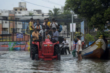 Ľudia sú evakuovaní zo zaplavených oblastí po silných dažďoch v indickom meste Čennaj. Záplavy spôsobil cyklón Michaung. FOTO: TASR/AP