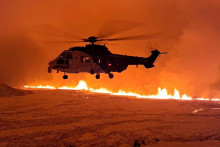Helikoptéra letí blízko sopky chrliacej lávu a dym pri jej erupcii neďaleko Grindaviku na Islande. FOTO: Reuters