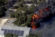 Na snímke z videa horiaca nehnuteľnosť počas lesného požiaru v austrálskom Perthe v novembri 2023. ILUSTRAČNÉ FOTO: TASR/AP