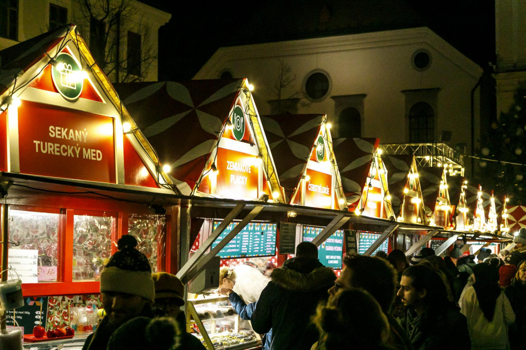 Ľudia stoja pred stánkami na vianočných trhoch na Hlavnom námestí v Bratislave. FOTO: TASR/Dano Veselský