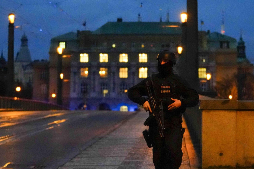 Policajt hliadkuje na moste ponad Vltavu neďaleko budovy Filozofickej fakulty Univerzity Karlovej po streľbe v centre Prahy. FOTO: TASR/AP