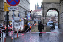 Policajt hliadkuje pred budovou Filozofickej fakulty Univerzity Karlovej po streľbe v centre Prahy