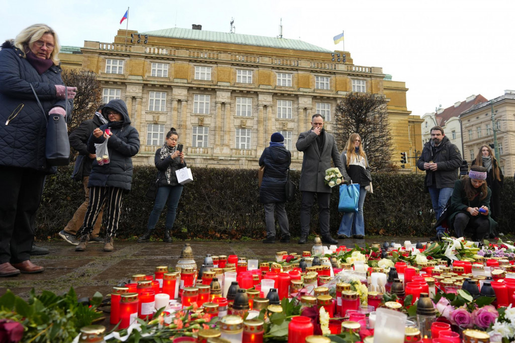 Ľudia zapaľujú sviečky a kladú kvety pred Filozofickou fakultou Karlovej univerzity na pamiatku obetí masovej streľby v centre Prahy. FOTO: TASR/AP