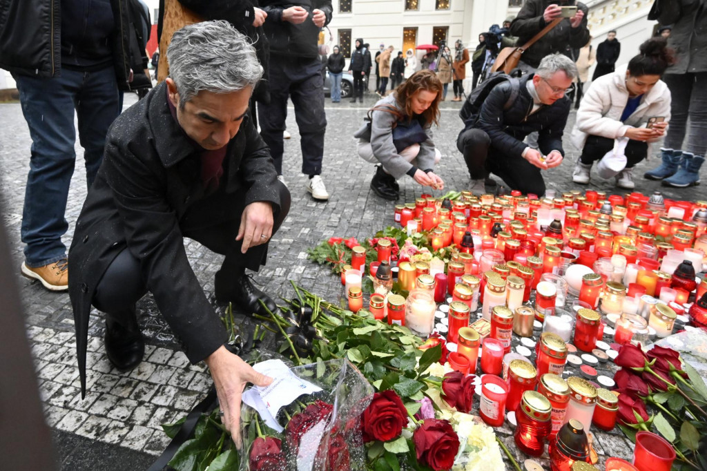 Americký veľvyslanec v Českej republike Bijan Sabet kladie kyticu kvetov pred sídlo Karlovej univerzity, kde sa nachádza pietne miesto na pamiatku obetí masovej streľby v centre Prahy.  FOTO: TASR/AP

