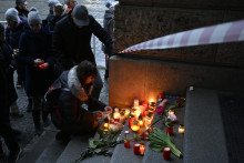 Ľudia prinášajú kvety a zapaľujú sviečky na schody pred Filozofickou fakultou Karlovej univerzity po masovej streľbe v centre Prahy. FOTO: TASR/AP