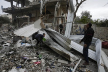 Palestínčania prehľadávajú trosky zničenej obytnej budovy. FOTO: TASR/AP