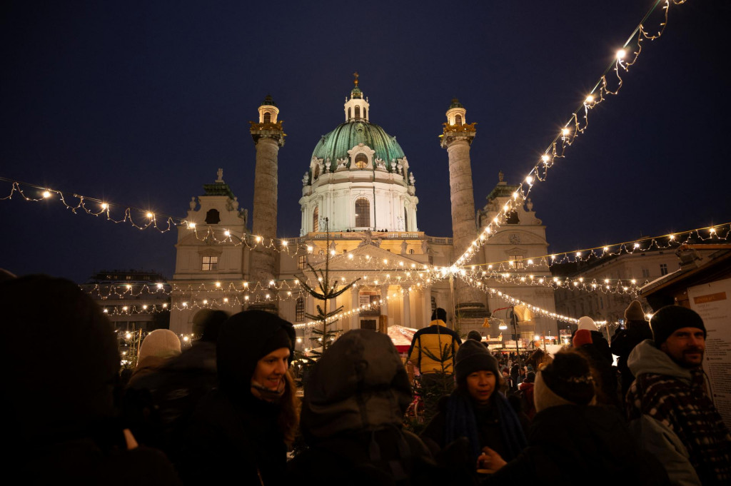 Ľudia navštevujú vianočný trh pred kostolom Karlskirche vo Viedni. FOTO: Reuters