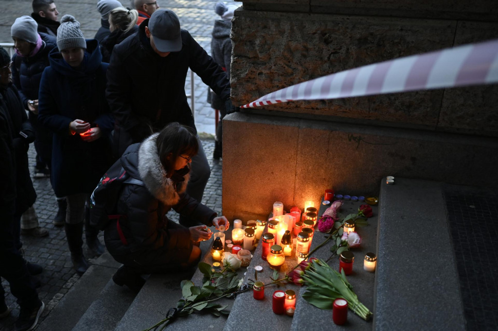 Ľudia prinášajú kvety a zapaľujú sviečky na schody pred Filozofickou fakultou Karlovej univerzity po masovej streľbe v centre Prahy. FOTO: TASR/AP