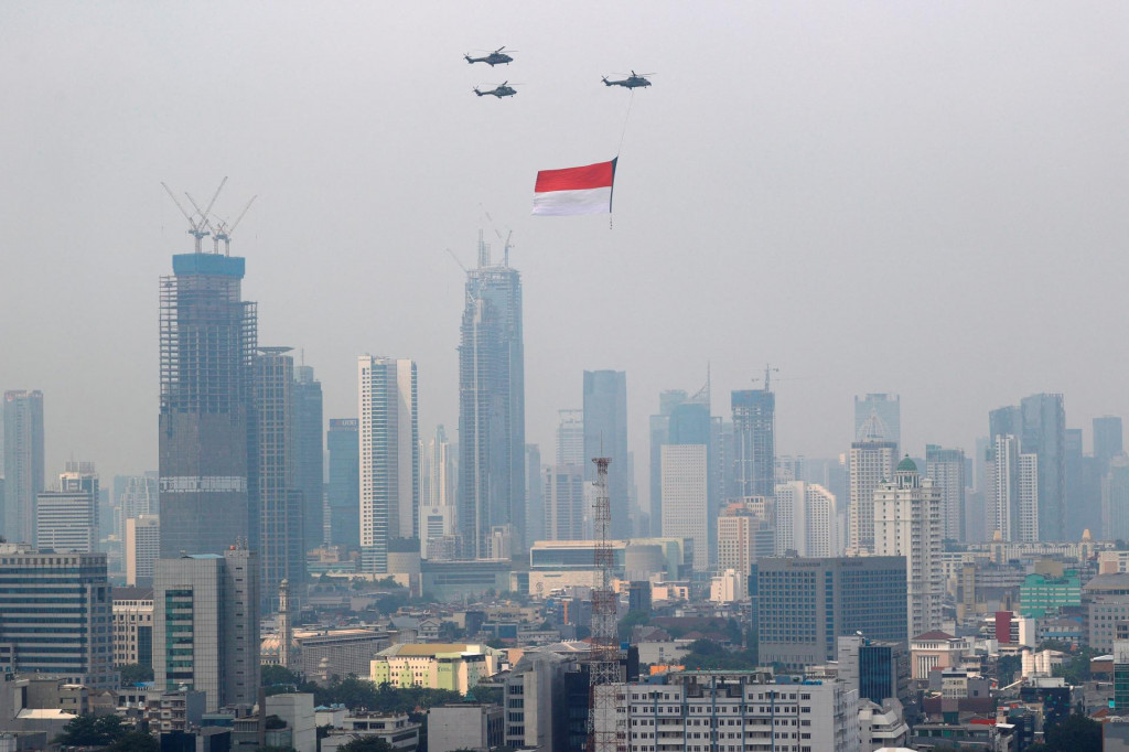 Vrtuľníky Indonézskych vzdušných síl nesú veľkú vlajku počas osláv Dňa nezávislosti. FOTO: Reuters