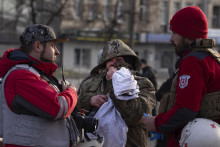 Zranená obyvateľka sa rozpráva so zdravotníkmi po ruskom raketovom útoku v Kyjeve. FOTO: TASR/AP