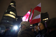 Pred budovou poľskej verejnoprávnej televízie TVP sa zhromaždili protestujúci a politici strany Právo a spravodlivosť po tom, čo nová vláda vyradila z vysielania verejnoprávny spravodajský kanál a odvolala vedenie štátnych médií. FOTO: Reuters