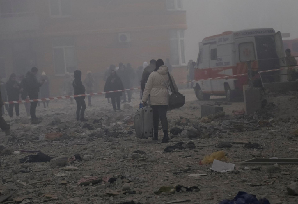 Miestni obyvatelia stoja v blízkosti svojej obytnej budovy zničenej počas útoku ruskej rakety a dronu uprostred ruského útoku na Ukrajinu v Odese na Ukrajine 29. decembra 2023. FOTO: Reuters