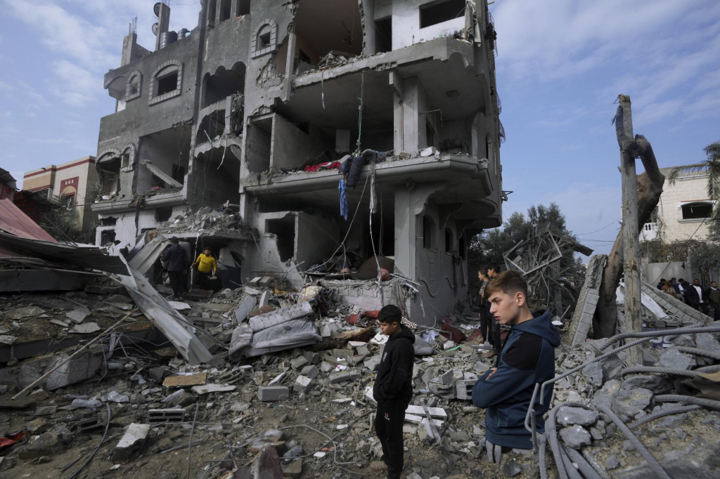 Palestínčania prehľadávajú trosky zničenej budovy po izraelskom leteckom útoku na pásmo Gazy v utečeneckom tábore v meste Maghazi. FOTO: TASR/AP