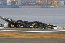 Zhorený vrak lietadla Airbus A350-900 leteckej spoločnosti Japan Airlines na Medzinárodnom letisku v Tokiu. FOTO: TASR/AP
