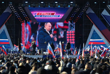 Ľudia sledujú prenos prejavu Vladimira Putina počas koncertu pri príležitosti ôsmeho výročia anexie Krymu. FOTO: Reuters