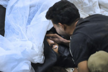 Muž plače nad telom svojej príbuznej, ktorá prišla o život pri výbuchu v iránskom meste Kermán. FOTO: TASR/AP