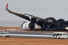 Úradníci vyšetrujú zhorené lietadlo Airbus A350 Japan Airlines po zrážke s lietadlom japonskej pobrežnej stráže na medzinárodnom letisku Haneda v Tokiu. FOTO: Reuters