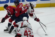 Center New Jersey Devils Michael McLeod sa snaží získať puk pred dvojicou hráčov Washingtonu Capitals Nickom Jensenom a slovenským obrancom Martinom Fehérvárym počas zápasu zámorskej NHL Washington Capitals - New Jersey Devils. FOTO: TASR/AP