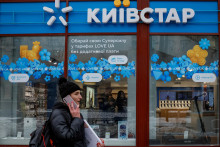 Žena prechádza okolo obchodu ukrajinskej telekomunikačnej spoločnosti Kyivstar. FOTO: Reuters