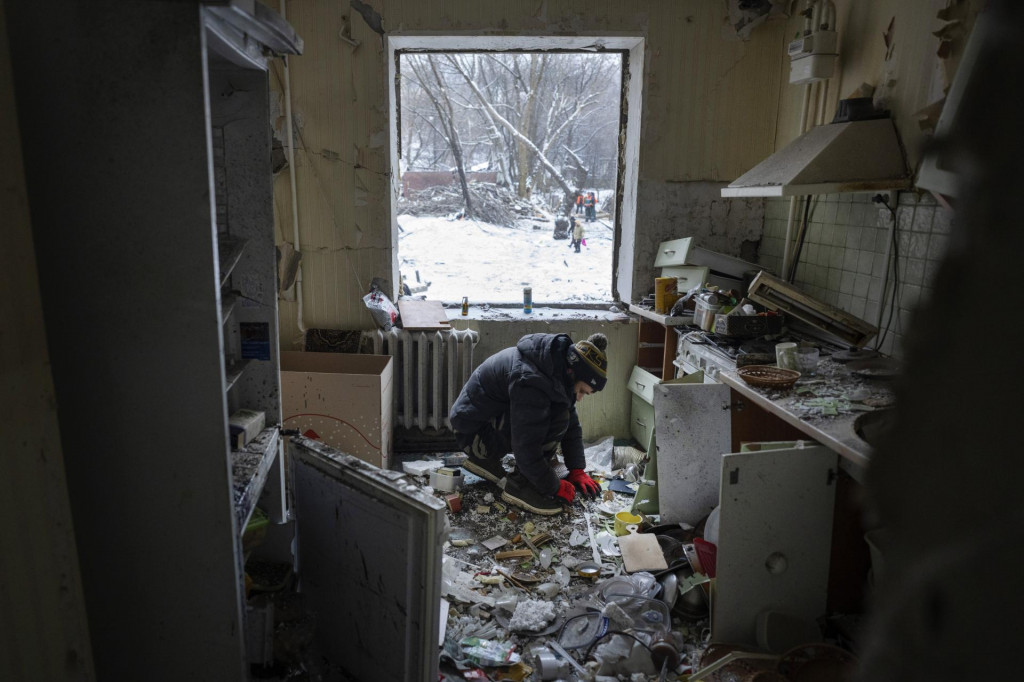 Muž zbiera trosky v kuchyni bytu po utorňajšom ruskom raketovom útoku, ktorý zasiahol obytnú štvrť v ukrajinskej metropole Kyjev. FOTO: TASR/AP