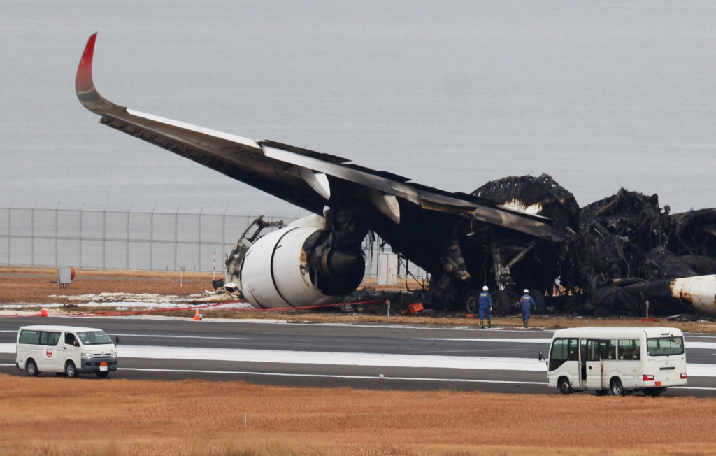 Úradníci vyšetrujú zhorené lietadlo Airbus A350 Japan Airlines po zrážke s lietadlom japonskej pobrežnej stráže na medzinárodnom letisku Haneda v Tokiu. FOTO: Reuters