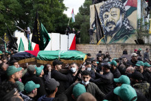 Muži nesú rakvu s pozostatkami zástupcu šéfa militantného palestínskeho hnutia Hamas Sáliha Árúrího počas pohrebu v Bejrúte. FOTO: TASR/AP