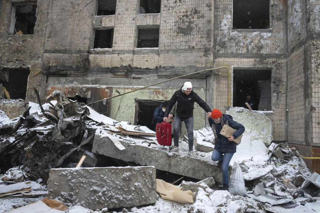 Ľudia odnášajú svoje osobné veci z obytného domu, ktorý zničil utorňajší raketový útok ruskej armády v ukrajinskej metropole Kyjev. FOTO: TASR/AP
