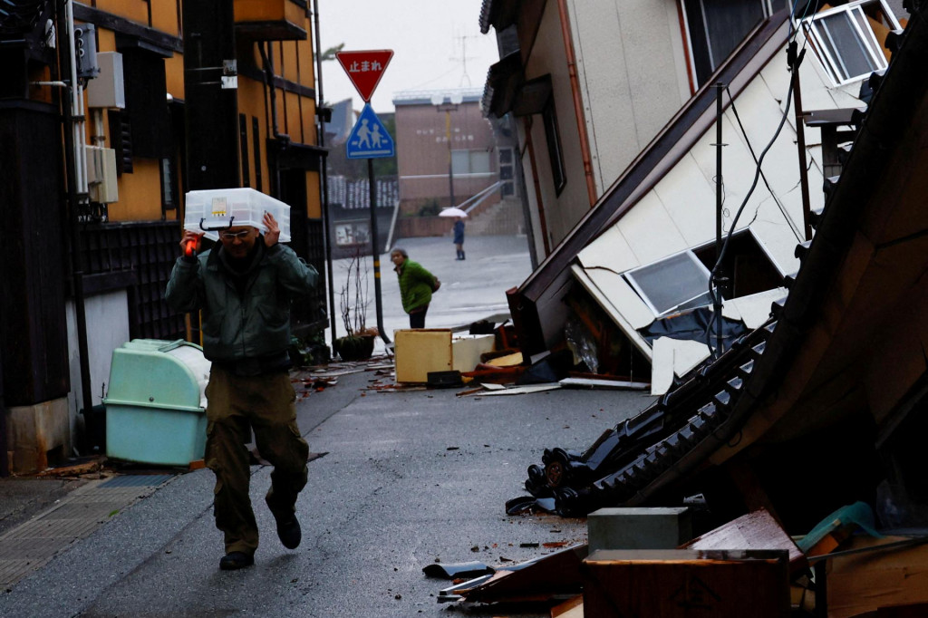 Muž v prefektúre Išikawa si ide vyzdvihnúť svoje veci predtým, ako sa po zemetrasení presťahuje do iného mesta. FOTO: Reuters