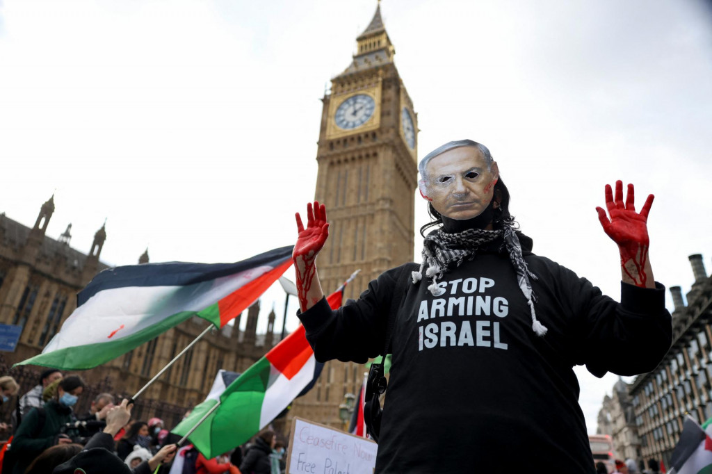 Osoba v maske izraelského premiéra Benjamina Netanjahua sa v Londýne zúčastňuje protestu solidarity s Palestínčanmi v Gaze. FOTO: Reuters