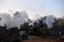 Izraelskí vojaci stoja pri mobilnej delostreleckej jednotke, ktorá strieľa na izraelskej strane izraelsko-libanonskej hranice.  FOTO: Reuters