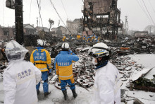 Policajti hľadajú obete v obytnom a obchodnom objekte, ktorý zhorel v dôsledku požiaru po zemetrasení v meste Wajima, prefektúra Ishikawa, Japonsko. FOTO: Reuters/Kyodo