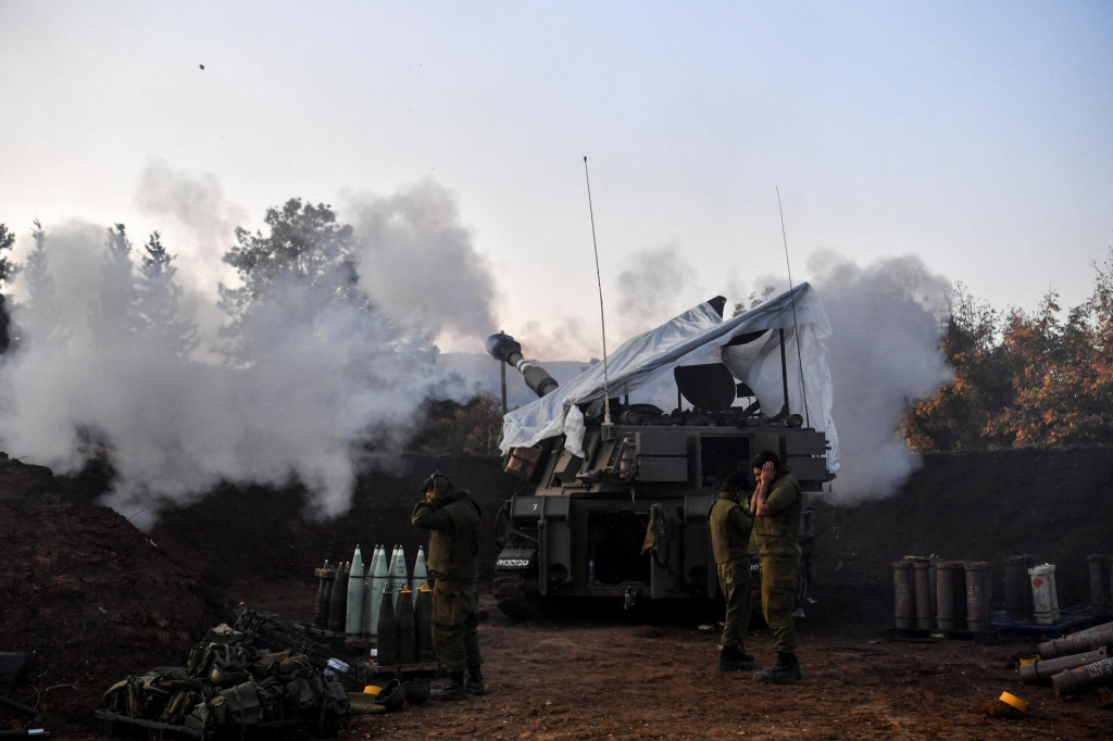Izraelskí vojaci stoja pri mobilnej delostreleckej jednotke, ktorá strieľa na izraelskej strane izraelsko-libanonskej hranice.  FOTO: Reuters