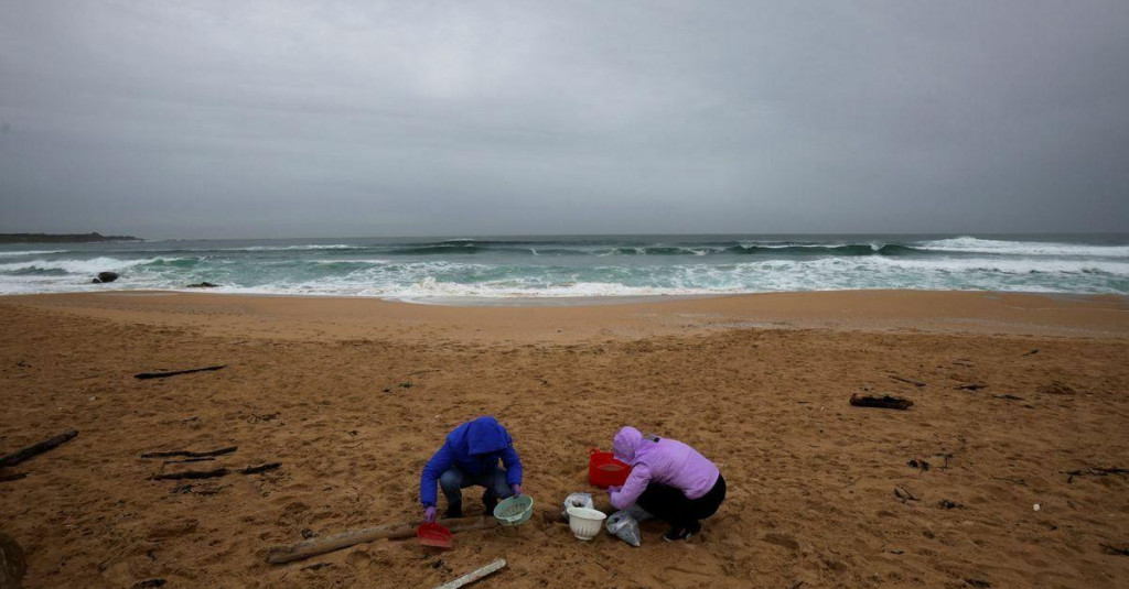 Ženy čistia piesok na pláži Vilar od miliónov plastových peliet vyplavených v regióne severozápadnej Galície v Španielsku. FOTO: Reuters