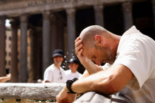 Muž sa ochladzuje pri fontáne v Ríme počas silnej vlny horúčav. FOTO: Reuters